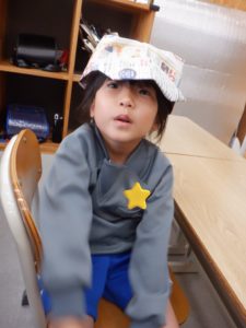 新聞紙で作った手作り帽子を上手に被る利用者様の様子