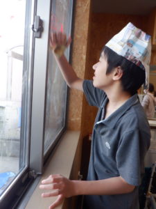 窓のペイントを布巾で丁寧に拭く利用者様の様子