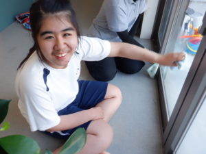 笑顔で窓拭きをされる利用者様の様子