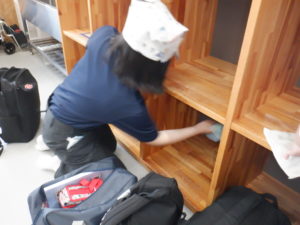 かばん棚の奥まで丁寧に拭く利用者様の様子