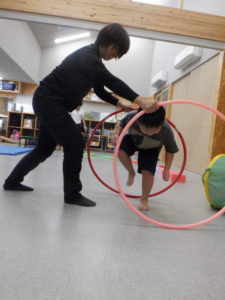 フラフープの中を懸命にくぐる利用者様