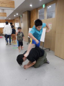 跳び箱役の職員の上を懸命に飛び越える利用者様