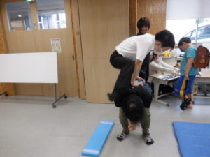 跳び箱役の職員の上を飛び越える利用者様