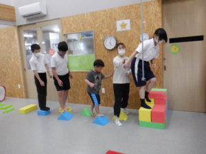 大型ブロック（三角など）の上でバランスを取る利用者様