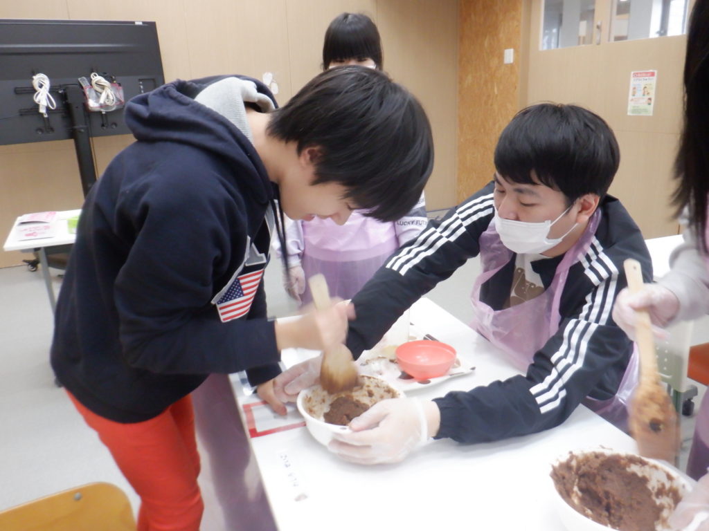 シュー生地を混ぜる利用者様と職員