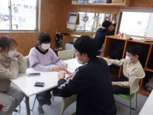 クッキーシューが焼きあがるまでの間、トランプをする利用者様と職員