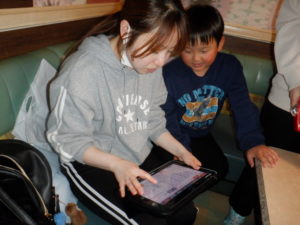 機器で曲を探す利用者様と職員